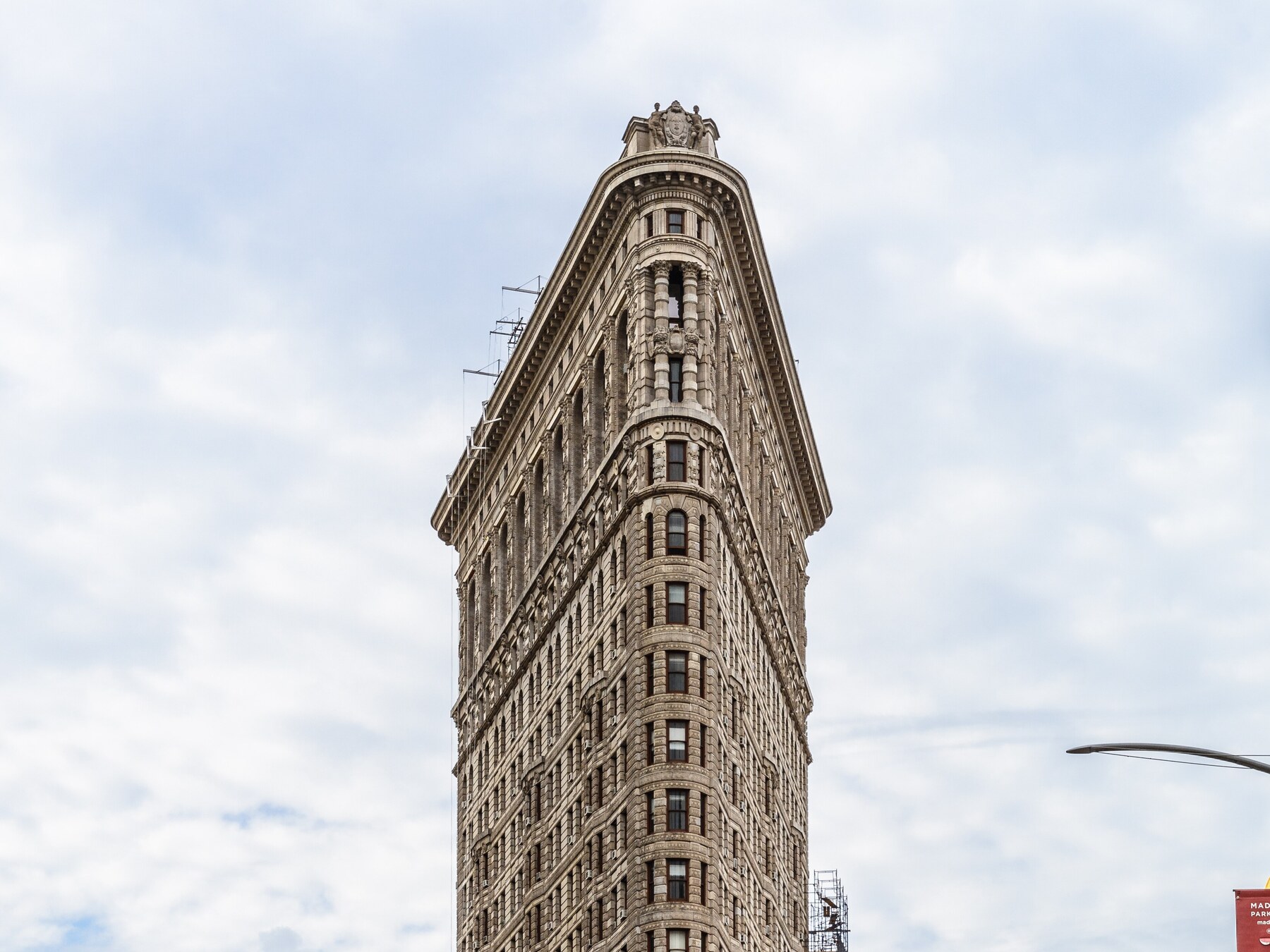 Upper limestone stories of the Flatiron Building against sky